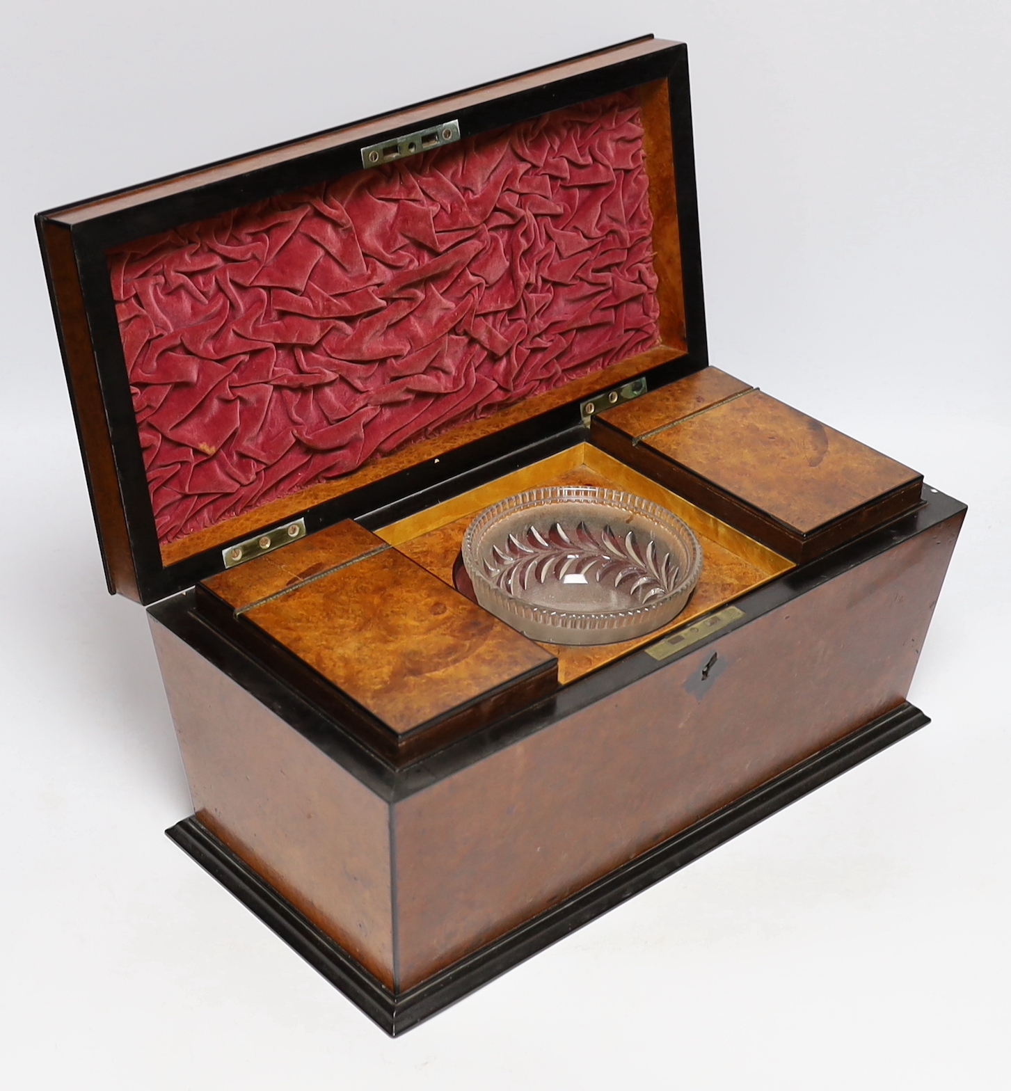 A George IV amboyna and ebony banded sarcophagus shaped tea caddy, with pedestal glass bowl, 35.5cm wide